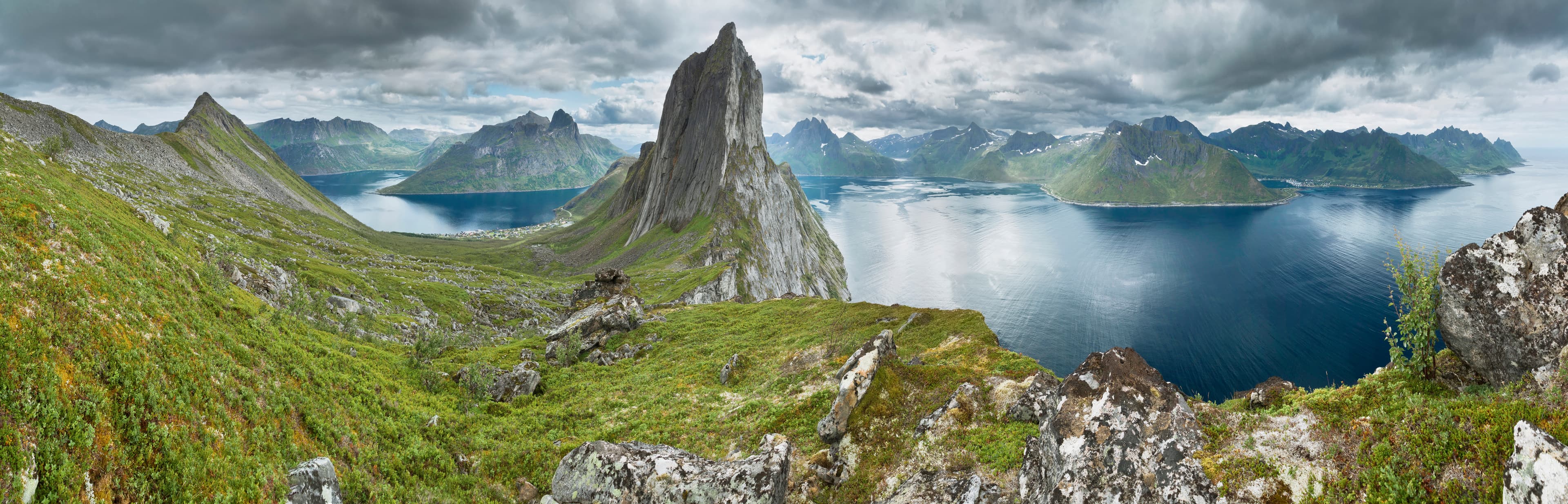 Ximonic (Simo Räsänen) · CC BY-SA 4.0 A panoramic view from a ridge located between Segla and Hesten mountain summits in the island of Senja, Troms, Norway in 2014 August. The fjord to the left is Øyfjorden with its sounds Trælvika and Ørnfjorden. The fjord to the right is Mefjorden.